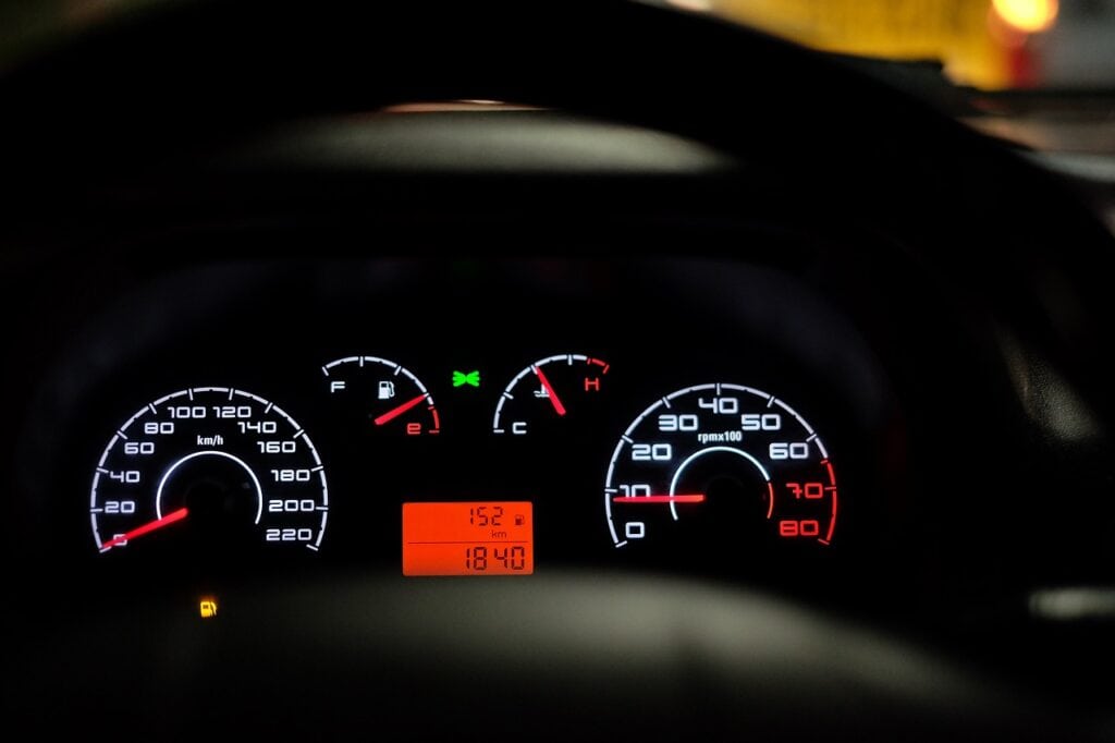 Car Overheating: Causes, Prevention, and Solutions A car's dashboard area showing the speedometer fuel gauge and temperature gauge rising to the high side